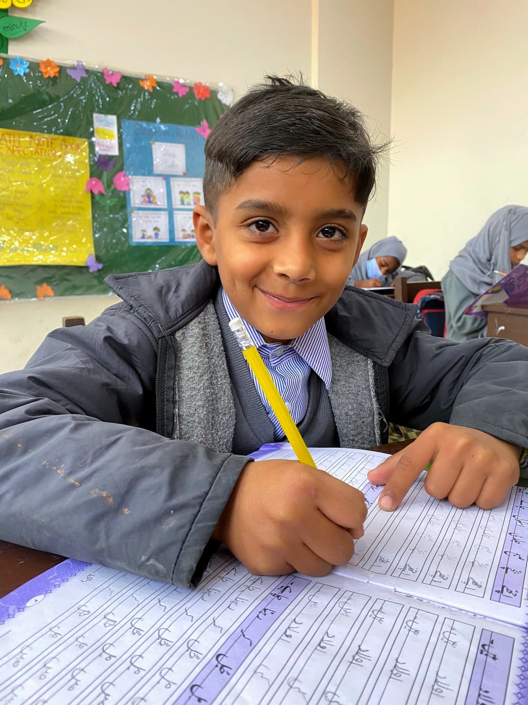 A student writing Urdu at the Qalam School